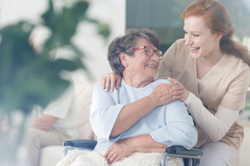 caregiver and senior woman smiling to each other